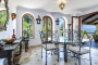 Seating area next to kitchen with large windows